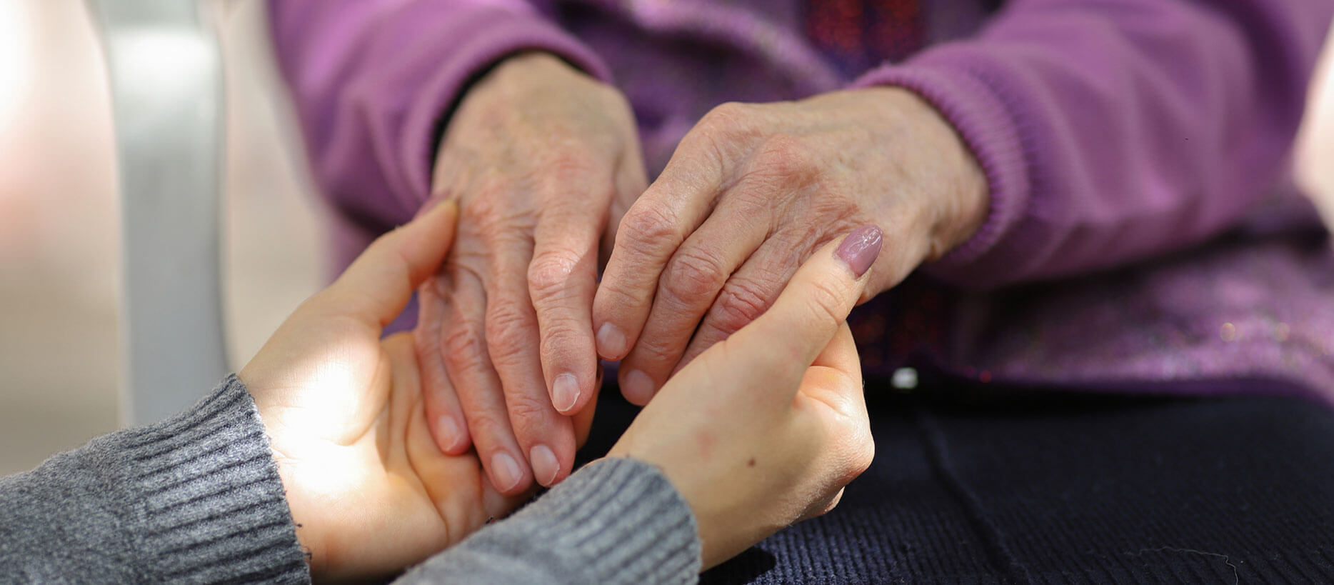 Woman holding elderly woman's hands